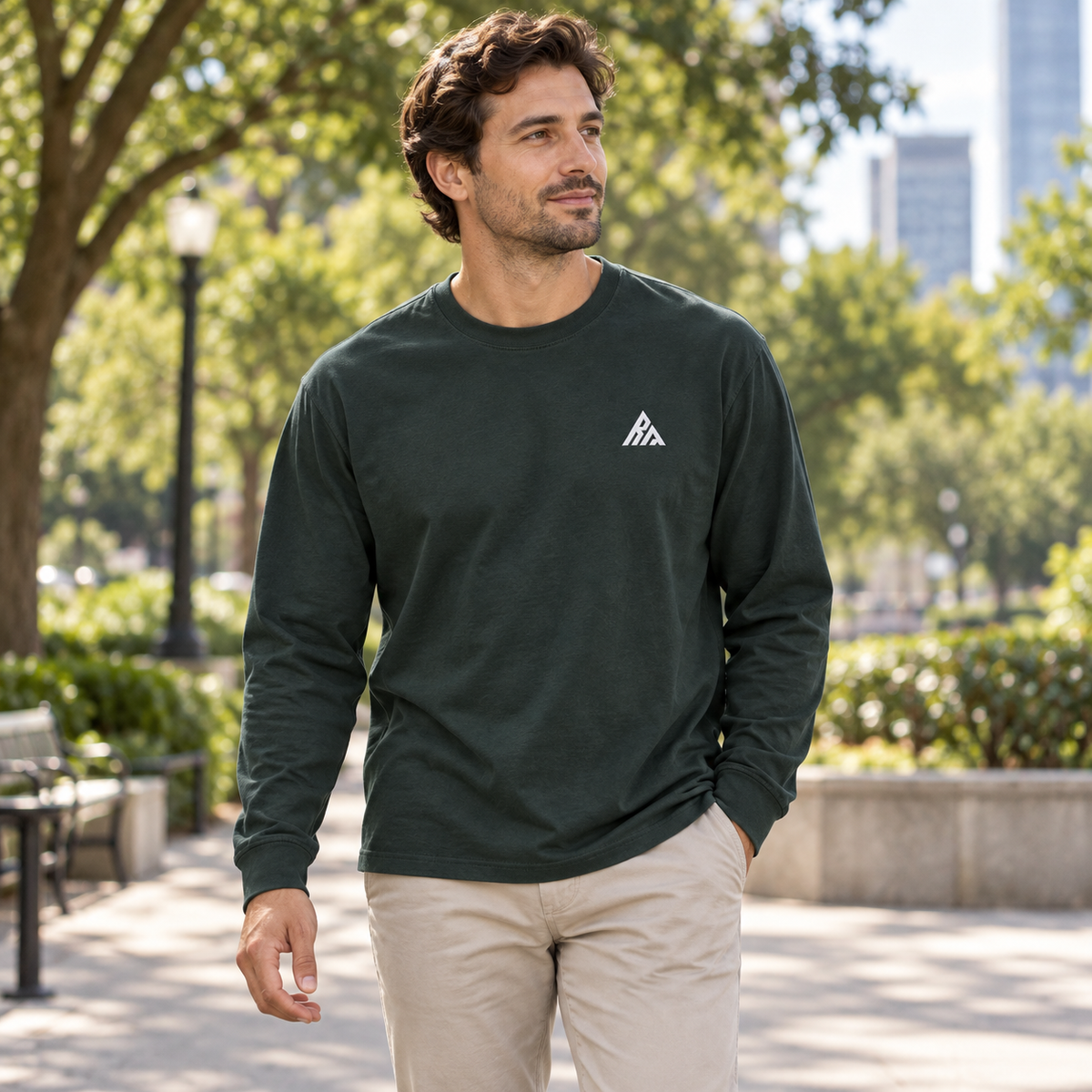 Man wearing the Real Marks relaxed long-sleeve T-shirt in forest green outdoors